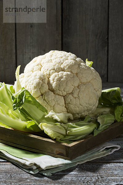 Cauliflower on wooden plate and table