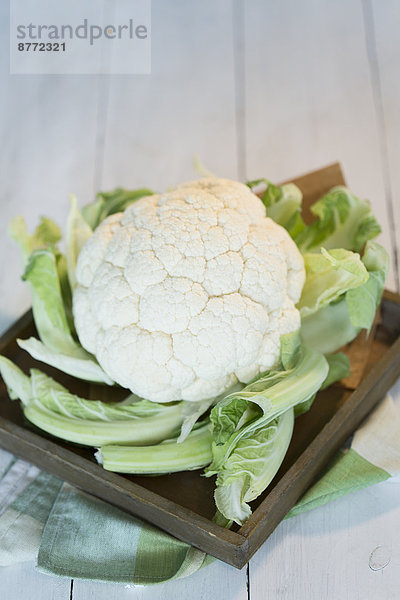 Cauliflower on wooden plate and table