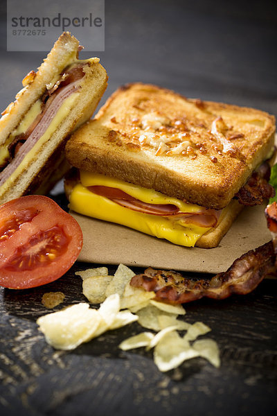 Sandwich mit Käse  Schinken  Speck und Tomaten