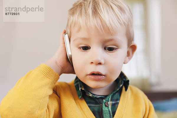 Portrait of toddler telephoning with smartphone