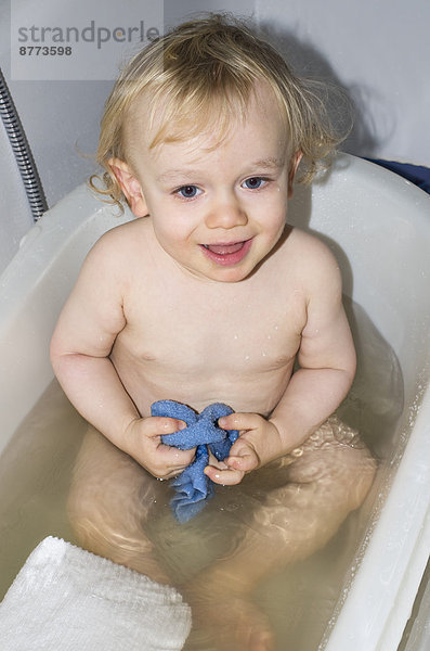 Lächelndes Kleinkind beim Baden in der Badewanne