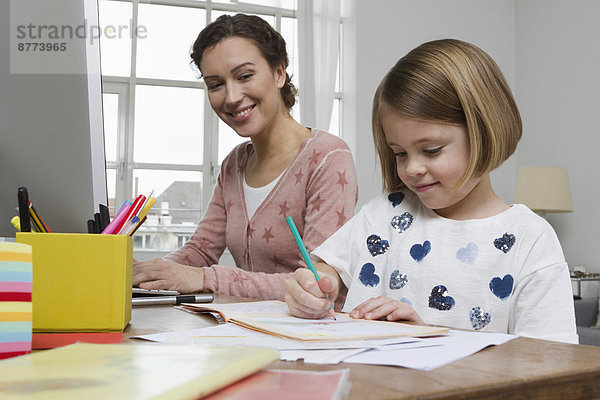 Mother with daughter at desk drawing