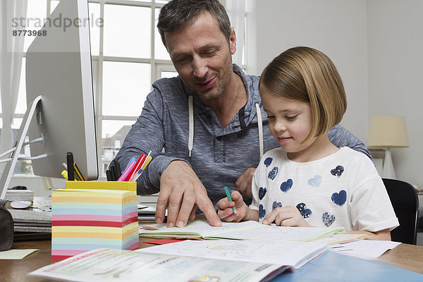 Vater mit Tochter am Schreibtisch zeichnen