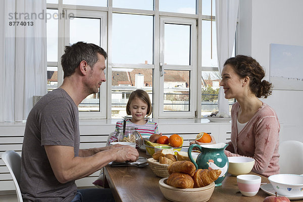 Father  mother and daughter having healthy breakfast