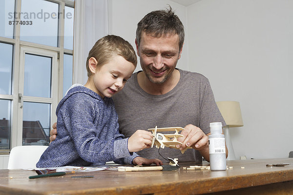 Father and son tinkering model airplane