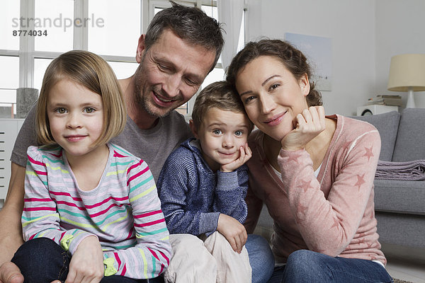 Happy family of four in living room