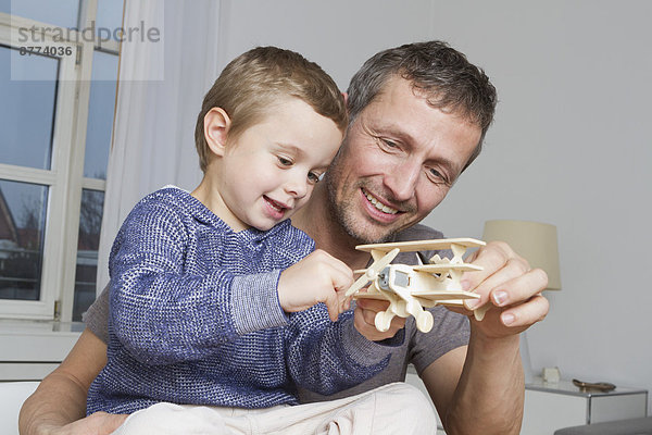 Father and son playing with model airplane