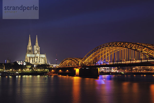 Deutschland  Nordrhein-Westfalen  Köln  Blick auf beleuchtete Hohenzollernbrücke und Kölner Dom bei Nacht