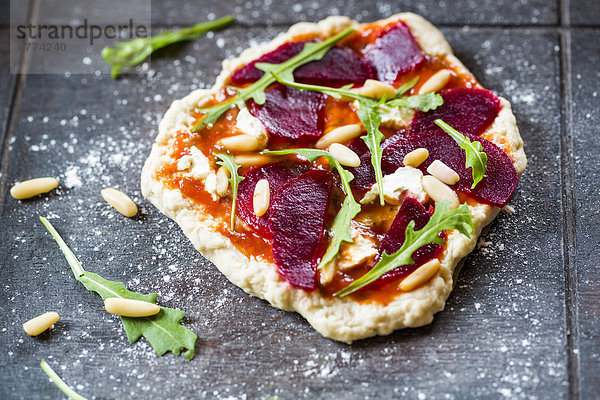 Mini pizza with beetroot  rucola and pine nuts