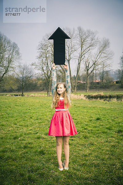 Germany  Landshut  Female teenager with black arrow sign