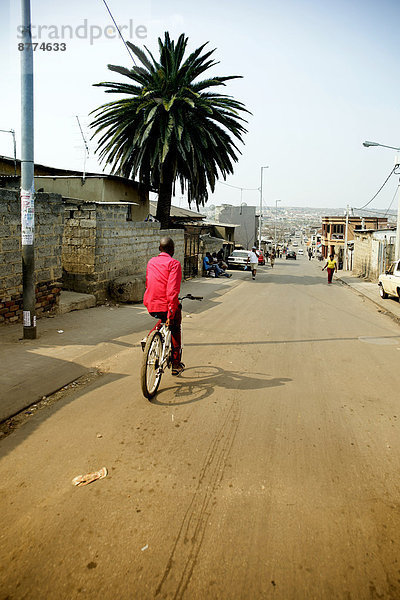 Südafrika  Johannesburg  Township Alexandra  Mann auf dem Fahrrad