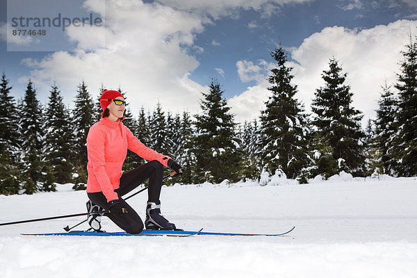 A woman cross-country skiing in the forest near Masserberg