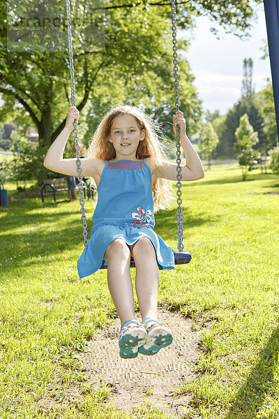 teenage girl on a swing in the park