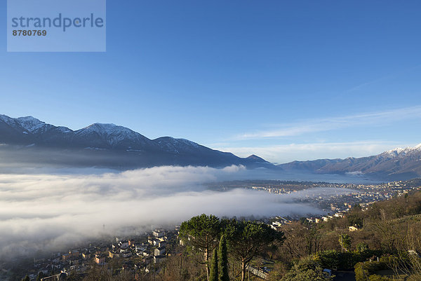 Europa Berg über unterhalb See Meer Nebel Dorf bedecken Locarno Schnee Schweiz