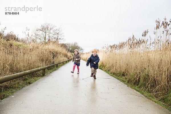 Junge Schwester und Bruder auf dem Landweg