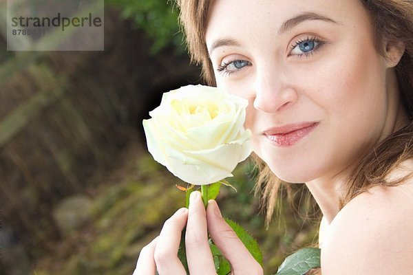 Porträt einer jungen Frau mit einer Rose