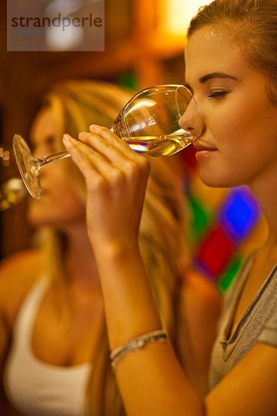 Zwei junge Frauen probieren Weißwein in der Weinstube