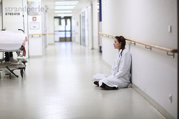 Ärztin sitzend im Kreuzbein im Krankenhausgang