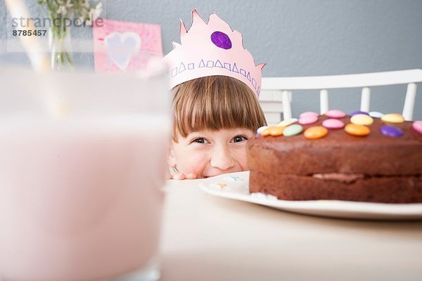 Mädchen versteckt sich hinter Kuchen