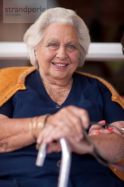 Porträt einer glücklichen älteren Frau mit Gehstock