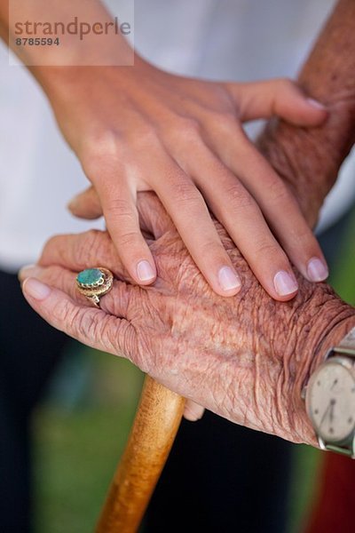 Nahaufnahme von Pflegehelferinnen Hand beruhigend Seniorin