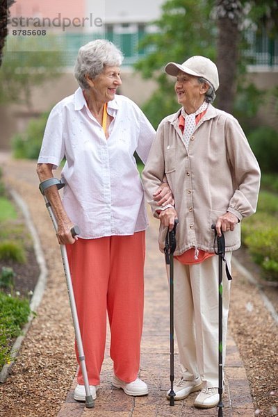 Zwei ältere Frauen beim Bummeln im Garten der Seniorenvilla
