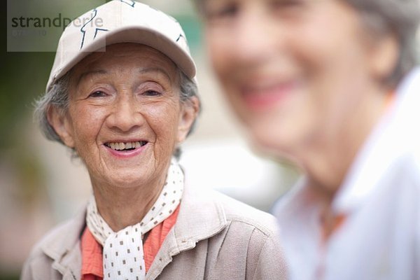 Zwei ältere Frauen im Seniorenvilla-Garten im Gespräch