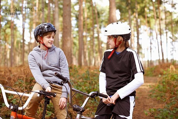 Zwillingsbrüder auf BMX-Bikes chatten im Wald