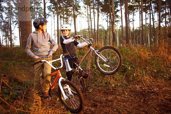 Zwillingsbrüder mit BMX-Bikes im Wald im Gespräch