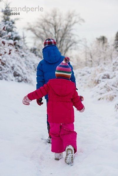 Geschwister wandern im Schnee