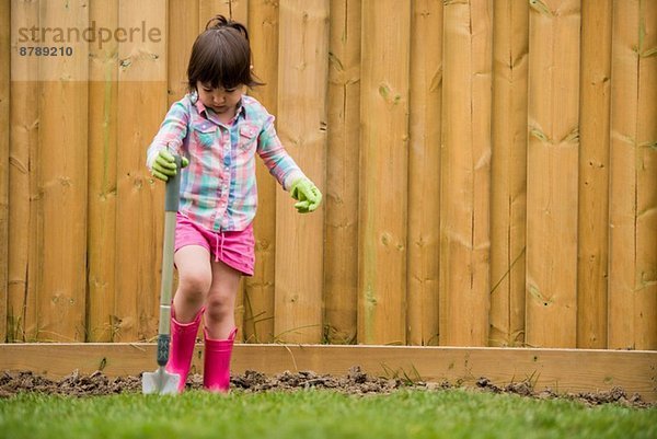 Junges Mädchen beim Erdgraben im Garten