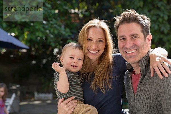 Vater und Mutter mit Baby im Garten