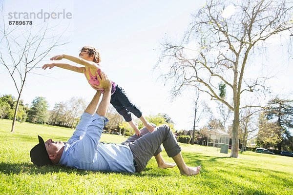 Mittlerer Erwachsener Mann spielt mit Tochter im Park