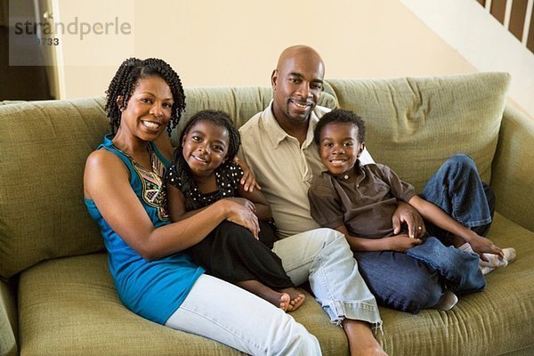 Porträt eines reifen Paares mit Sohn und Tochter auf dem Sofa