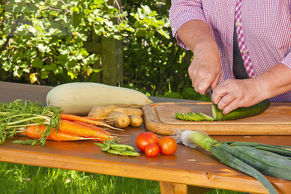 Europa  Frau  schneiden  Gemüse  Schneidebrett  Garten  Koch  Tomate  Kartoffel  Bohne  Lauch  Gurke  Zucchini  Bayern  Deutschland
