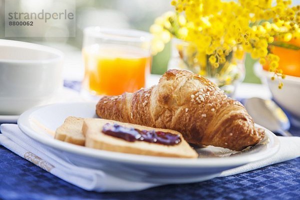 Frühstück mit Croissant  Zwieback und frischem Orangensaft