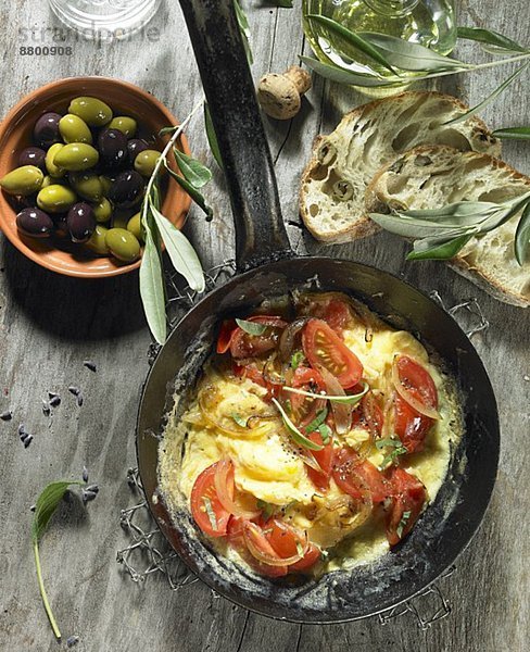 Tomatenrührei mit Zwiebeln  schwarze und grüne Oliven  Olivenöl  Olivenzweig  Oliven-Ciabatta und Lavendel