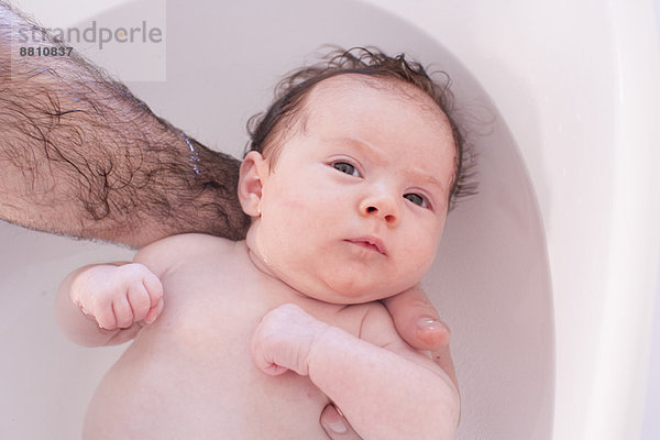 Elternteil badendes Baby  abgeschnitten