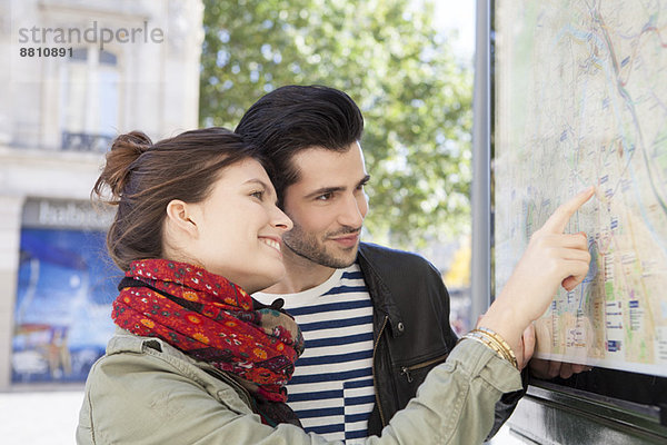 Touristenpaar schaut sich den Stadtplan an der Touristeninformation an.