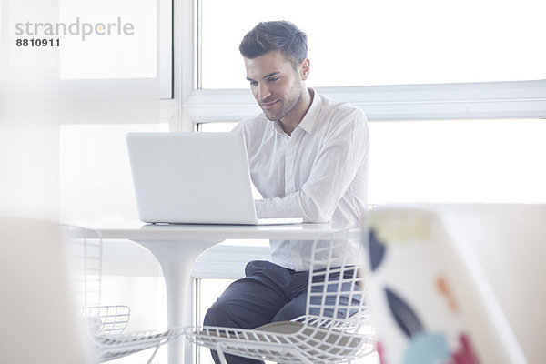 Mann mit Laptop-Computer im Café