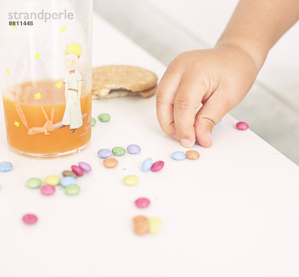 Kind holt Bonbons vom Tisch ab