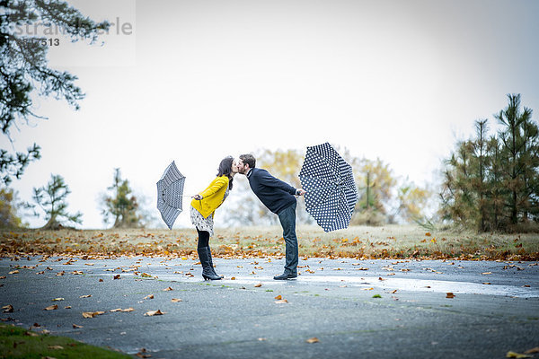 Außenaufnahme  Europäer  Regenschirm  Schirm  küssen  freie Natur
