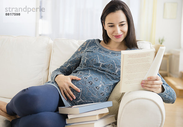 Europäer Frau Couch Buch Schwangerschaft Baby vorlesen
