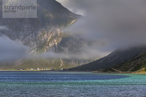 Nebel zieht in einen Fjord bei Flakstad  hinten Vareid  Flakstadøy  Lofoten  Nordland  Norwegen