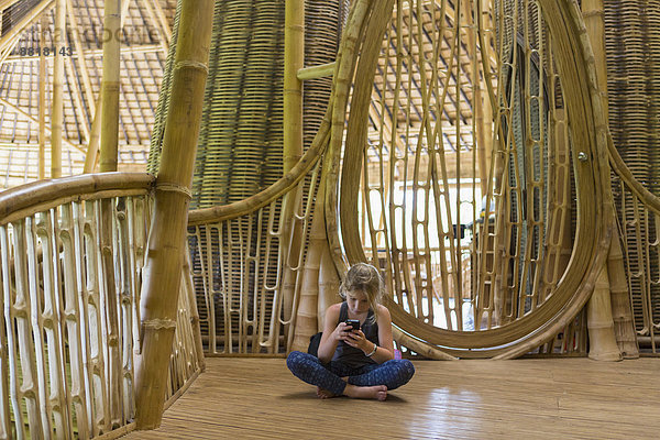 Handy benutzen Europäer Wohnhaus Bambus Mädchen