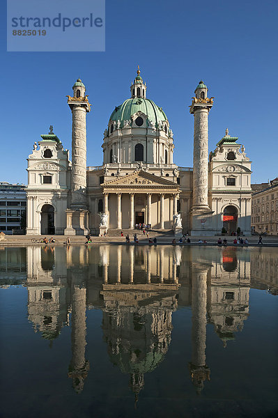 Barocke Karlskirche  1739 fertiggestellt  mit Spiegelung im Tilgner Brunnen  die Säulen zeigen in einem Spiralrelief Motive aus dem Leben Karl Borromäus'  Wien  Land Wien  Österreich