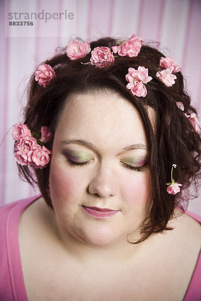 Porträt einer Frau mit geschlossenen Augen und rosa Blüten