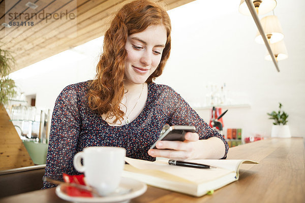Portrait einer jungen Frau mit Smartphone Lesung SMS
