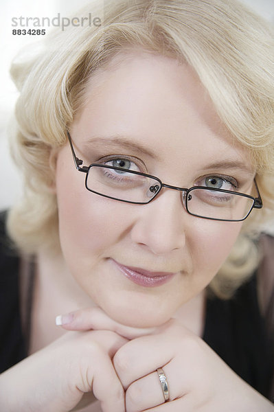 Porträt einer blonden jungen Frau mit Brille