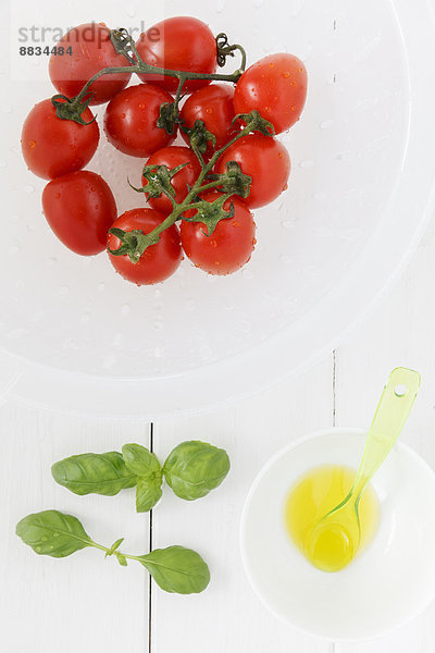Frische Tomaten in einem Sieb und Öl